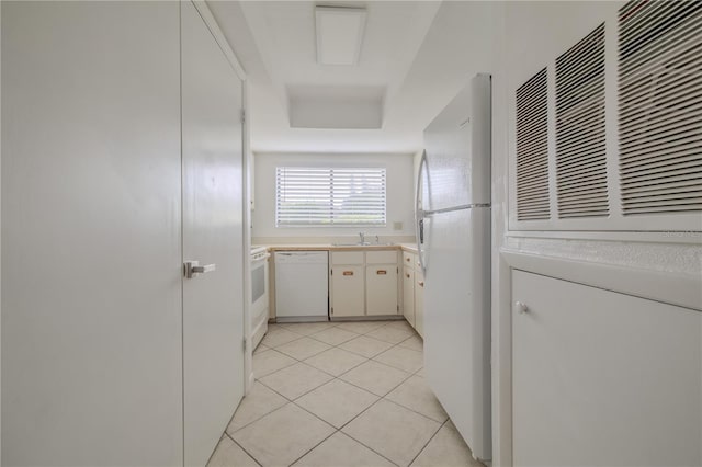 kitchen featuring white cabinets, sink, white appliances, and light tile patterned floors