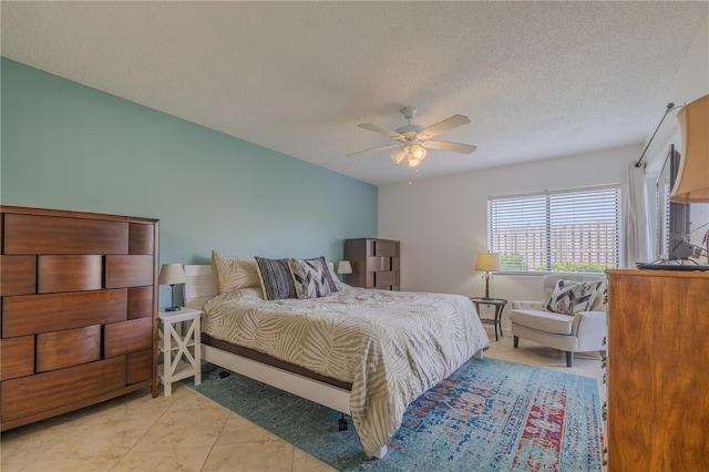 tiled bedroom with a textured ceiling and ceiling fan