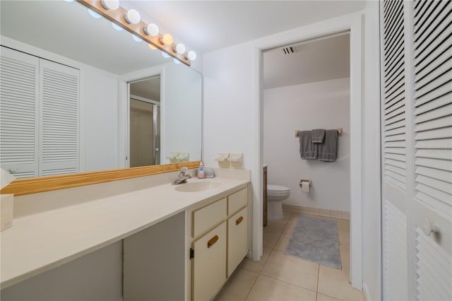 bathroom featuring vanity, tile patterned flooring, and toilet