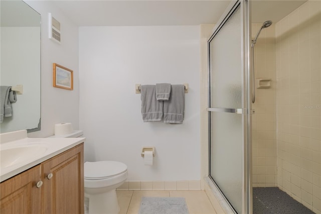 bathroom with toilet, vanity, tile patterned floors, and walk in shower