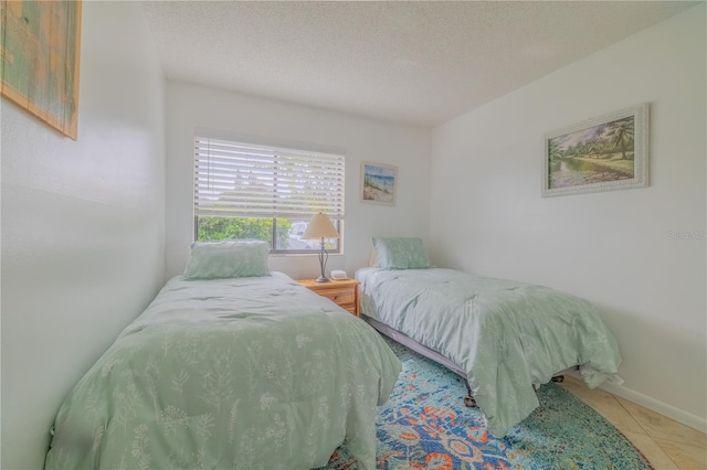 bedroom with a textured ceiling and light tile patterned floors