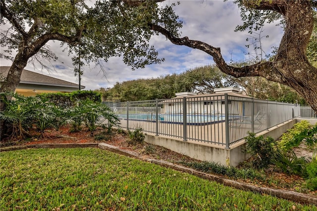 view of swimming pool featuring a yard