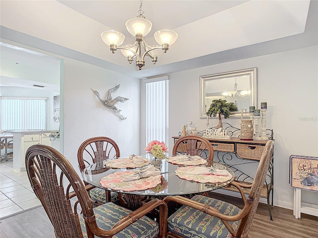 dining space featuring light hardwood / wood-style flooring and a notable chandelier