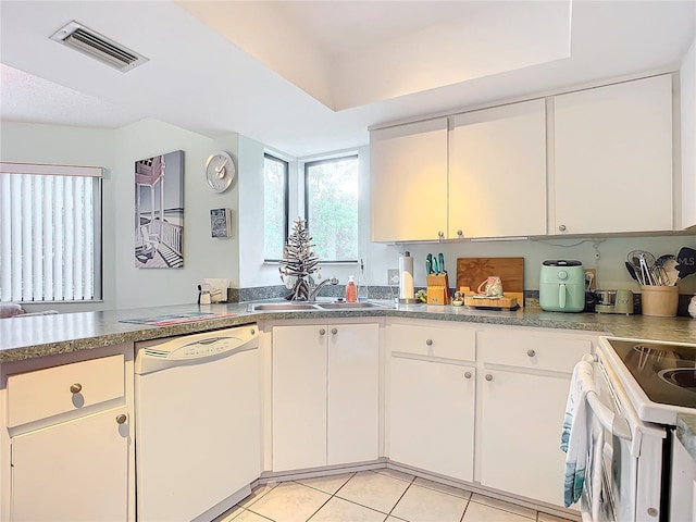 kitchen with light tile patterned floors, white appliances, white cabinetry, and sink