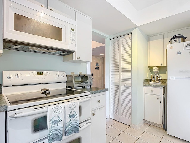 kitchen featuring white appliances, white cabinetry, and light tile patterned flooring