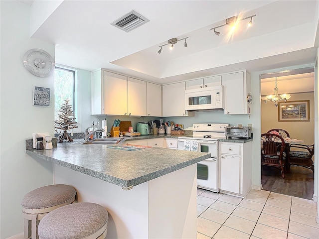 kitchen featuring white cabinets, kitchen peninsula, and white appliances