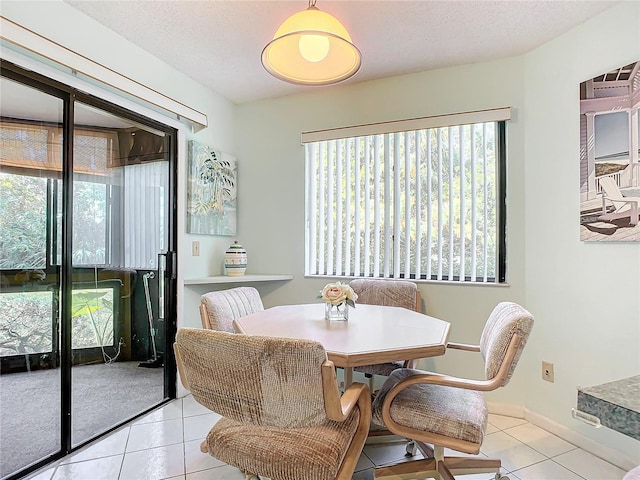 dining room featuring a textured ceiling and light tile patterned floors