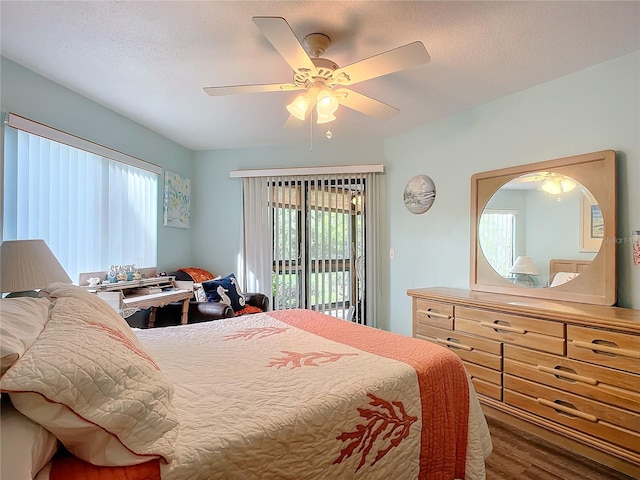 bedroom featuring dark wood-type flooring, a textured ceiling, ceiling fan, and access to exterior