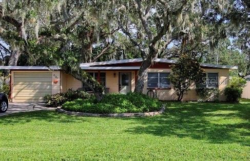 single story home featuring a garage and a front yard