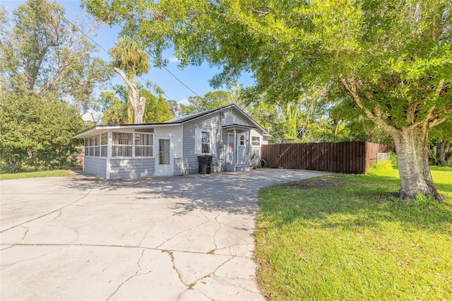 view of front of property featuring a sunroom and a front lawn