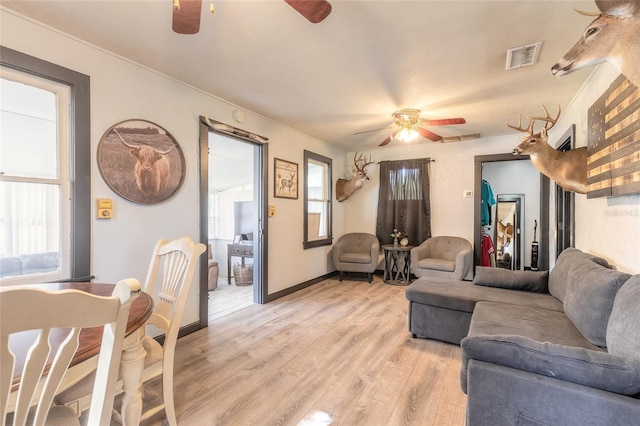 living room with ceiling fan and light wood-type flooring