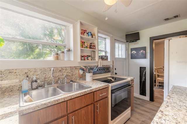 kitchen featuring sink, light hardwood / wood-style flooring, ceiling fan, and electric stove