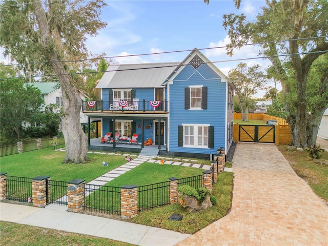 view of front of house with covered porch, a front yard, and a balcony