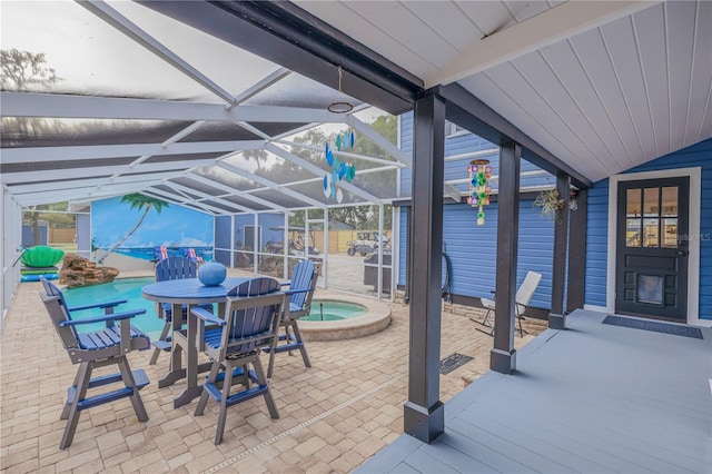 view of patio featuring glass enclosure and a pool with hot tub