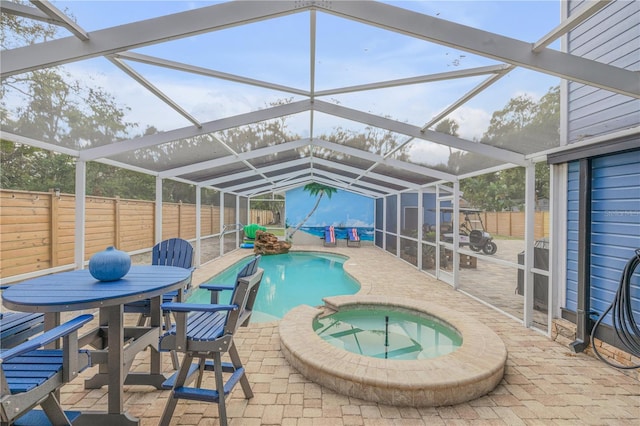 view of pool featuring glass enclosure, a patio area, and an in ground hot tub