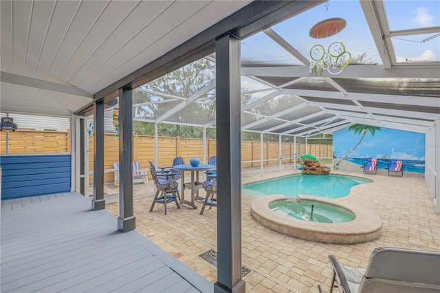 view of pool with glass enclosure, an in ground hot tub, and a patio area