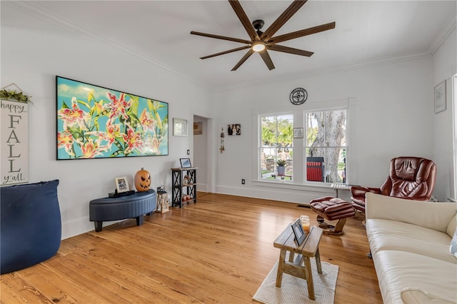 living room featuring light hardwood / wood-style floors, ceiling fan, and crown molding