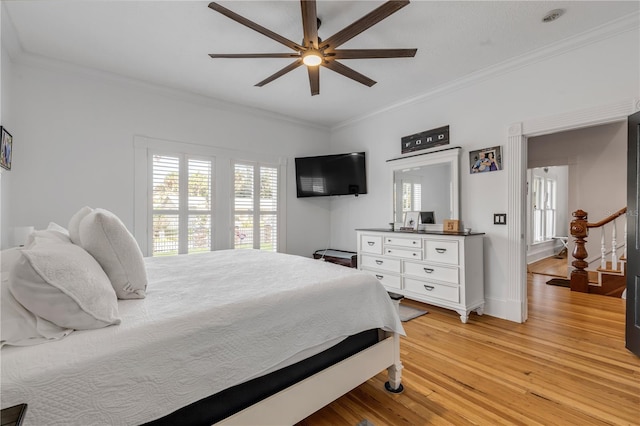 bedroom with ornamental molding, ceiling fan, and light hardwood / wood-style flooring