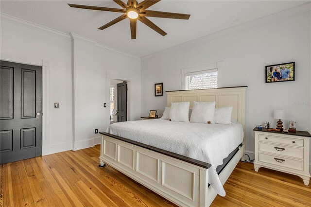 bedroom with light hardwood / wood-style floors, ceiling fan, and crown molding