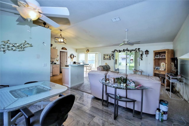 kitchen with lofted ceiling, ceiling fan with notable chandelier, decorative light fixtures, and kitchen peninsula