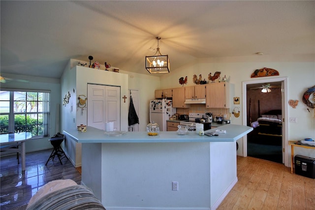 kitchen featuring vaulted ceiling, white fridge, electric range, light brown cabinets, and decorative light fixtures