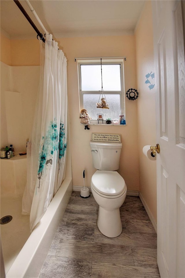 bathroom with hardwood / wood-style flooring, shower / bath combo, and toilet