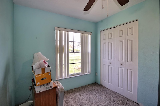 carpeted bedroom with ceiling fan and a closet