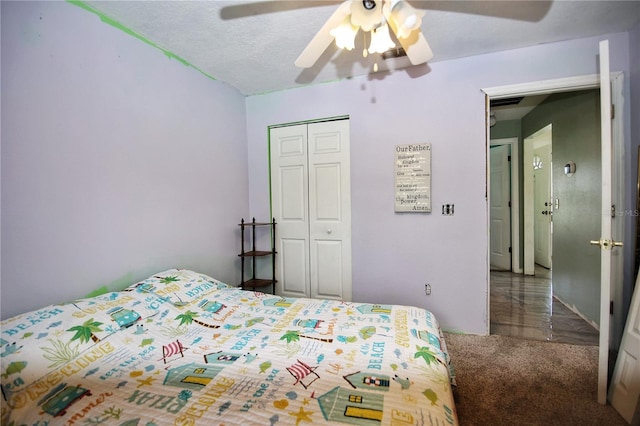 carpeted bedroom featuring ceiling fan, a textured ceiling, and a closet