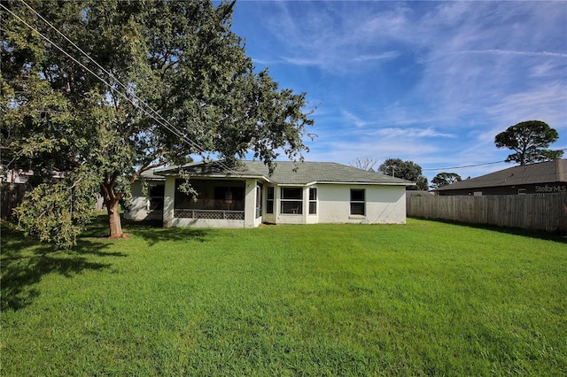 rear view of property featuring a yard