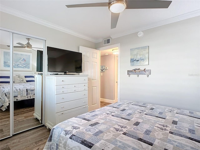 bedroom with ceiling fan, a closet, wood-type flooring, and ornamental molding