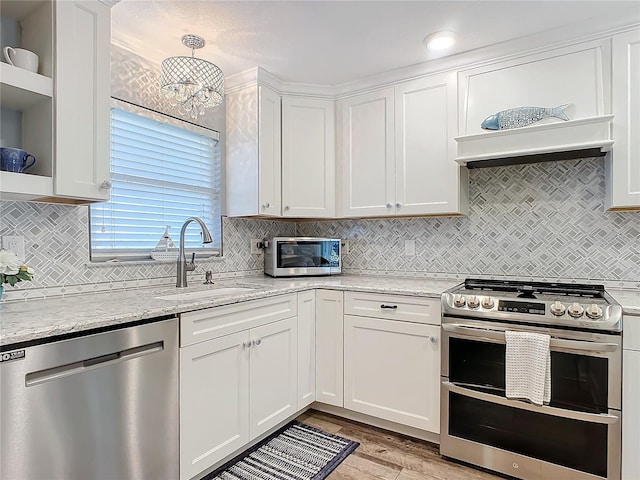 kitchen featuring light stone countertops, white cabinetry, sink, stainless steel appliances, and light hardwood / wood-style flooring