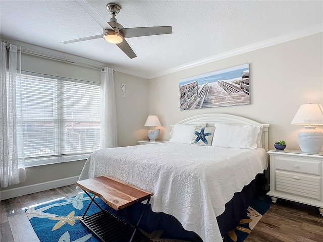 bedroom with a textured ceiling, ceiling fan, ornamental molding, and dark wood-type flooring