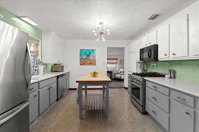 kitchen with white cabinets, gray cabinetry, stainless steel appliances, and a wealth of natural light