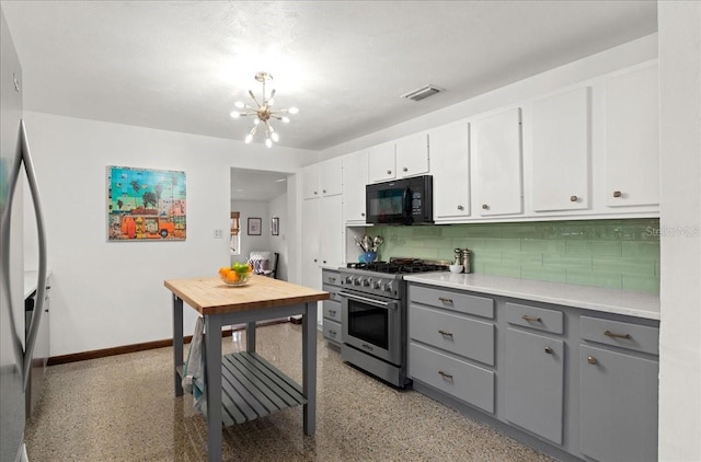 kitchen featuring an inviting chandelier, decorative backsplash, gray cabinets, appliances with stainless steel finishes, and white cabinetry