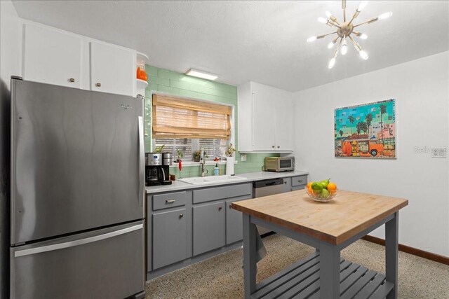 kitchen featuring gray cabinetry, sink, tasteful backsplash, white cabinetry, and stainless steel appliances