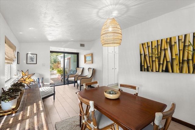 dining room with lofted ceiling and light hardwood / wood-style flooring