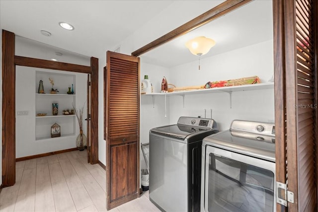 clothes washing area with independent washer and dryer and light hardwood / wood-style flooring