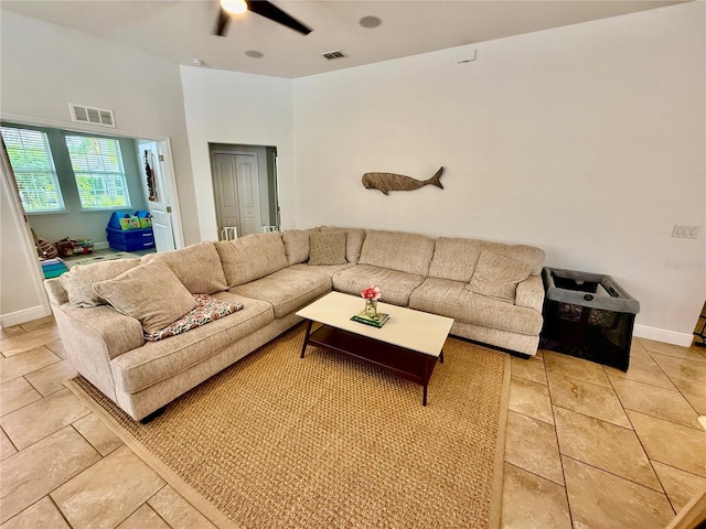 living area with a ceiling fan, visible vents, baseboards, and light tile patterned flooring