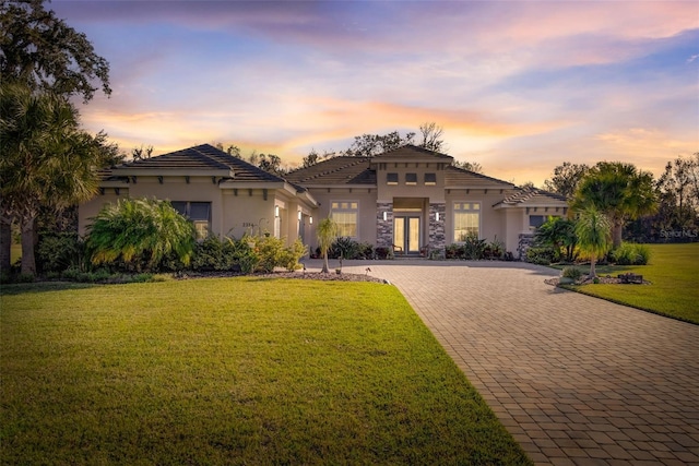 mediterranean / spanish home featuring a lawn