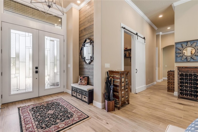 foyer entrance with a barn door, french doors, and light hardwood / wood-style flooring