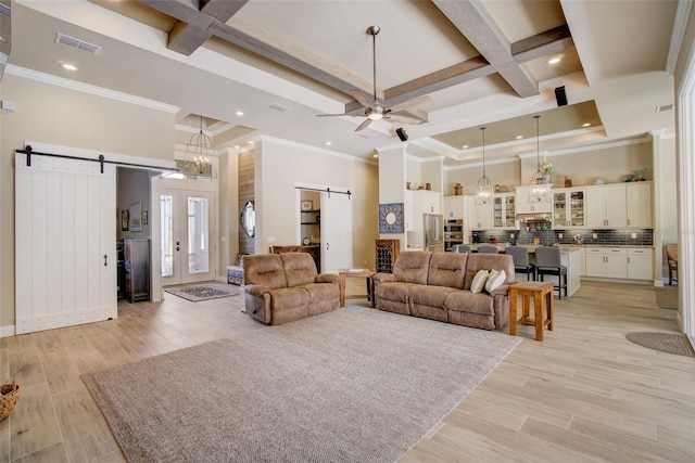 living room with coffered ceiling, a barn door, ceiling fan, and light hardwood / wood-style flooring