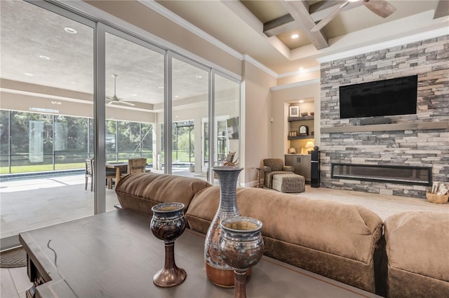 living room with ornamental molding, a fireplace, beam ceiling, coffered ceiling, and ceiling fan