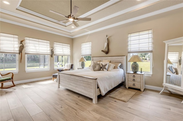 bedroom with a raised ceiling, ceiling fan, and light hardwood / wood-style flooring