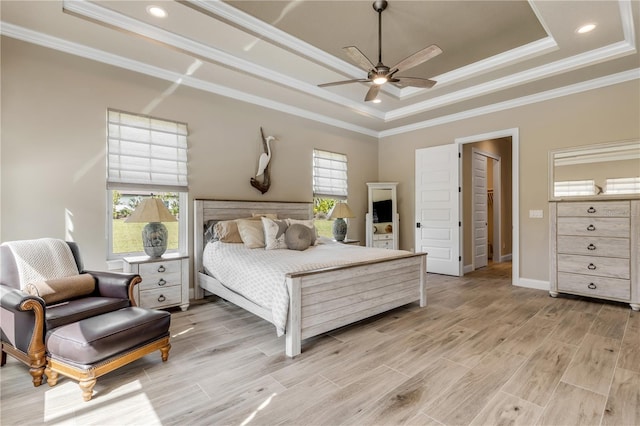 bedroom featuring ornamental molding, multiple windows, ceiling fan, and a tray ceiling