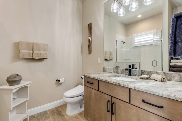 bathroom with wood-type flooring, vanity, toilet, and an enclosed shower