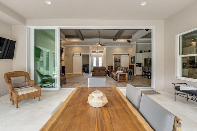 dining area with light tile patterned flooring, a barn door, coffered ceiling, beamed ceiling, and ceiling fan