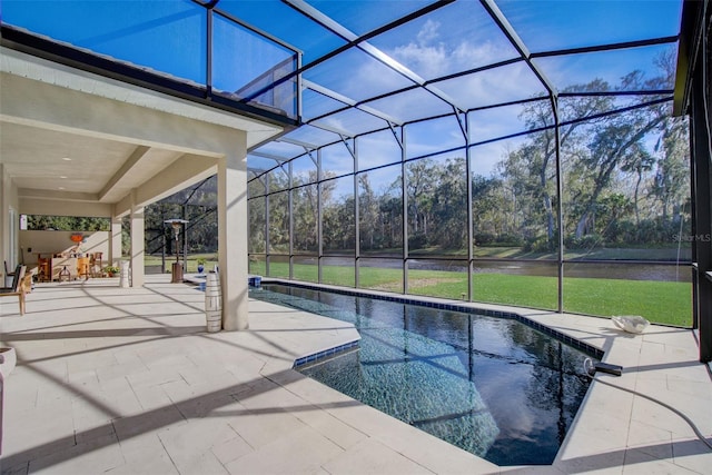 view of pool featuring a lawn, glass enclosure, and a patio