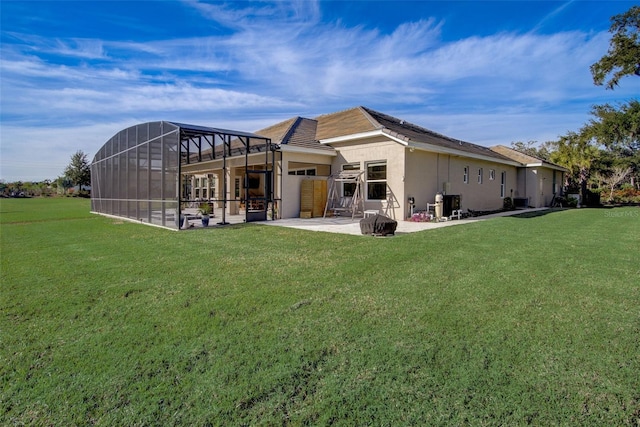 back of property with glass enclosure, a lawn, and a patio area