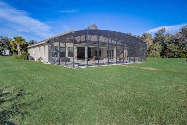 back of house with glass enclosure, a patio area, a yard, and a pool