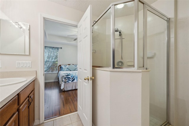 bathroom featuring hardwood / wood-style flooring, vanity, a shower with door, and a textured ceiling